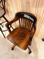 Front angled view of oak swivel banker chair
