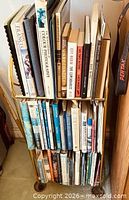 Full view of three-shelf metal stand loaded with books