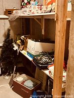 Basement shelf with artificial tree, cooler, boxes, cords