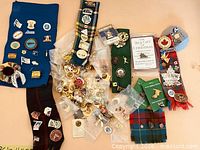 Wide view of assorted pins on fabric and loose in bags