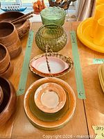 Top view of all seven glass and porcelain pieces aligned within green tape