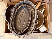 box showing speckled enamel roaster, colander, utensils