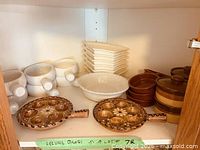 Cabinet view showing entire assortment of white and brown dishes