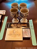 Four alabaster goblets, boxed items on table
