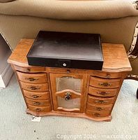 Wooden jewelry chest with black jewelry box placed on top