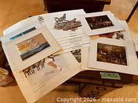 Stack of assorted matted and loose prints on table