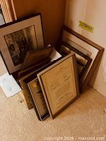 Group of assorted frames leaning against wall