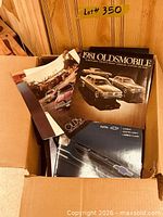 Open box showing 1981 Oldsmobile brochure, 1996 Chevrolet brochure and others