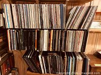 Three shelves densely filled with vinyl LP records