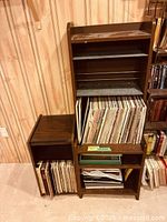 Vinyl records stored in brown wood cabinet