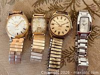 Front view of four wristwatches lined side by side