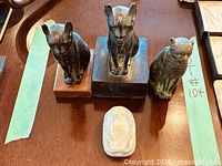 Overview of three cat statues and stone plaque