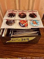 Top view showing six buttons on Collect-A-Button cards and remaining cards in metal box