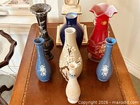Group shot of all seven vases on table
