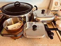 Group shot showing slow cooker, two electric skillets, deep fryer