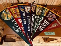 Group view of nine overlapping felt pennants on dresser