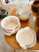 Group view of mixing bowls, handled dishes and glass refrigerator containers on tabletop