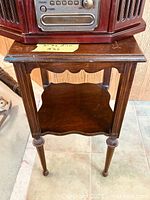 Front angled view of wooden end table showing top, lower shelf, legs
