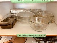 Shelf with assorted clear and amber glass baking dishes, bowls and casseroles