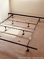 full view of assembled black metal king bed frame on carpeted floor