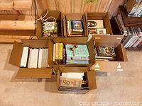 Overhead view of seven boxes filled with assorted books