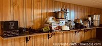 Full shelf view showing assorted cookware, bowls, kettles and boxed items