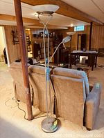 Full view of brushed steel floor lamp behind seating