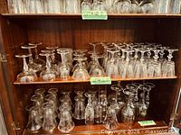Two shelves filled with inverted crystal stemware of various types