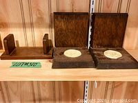 Left small plain piece and right two medallion bookends on shelf