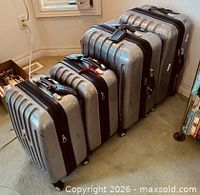 Four silver hardshell suitcases lined up to show sizes