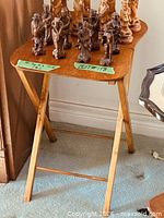 Full view of wooden folding tray table with objects on top