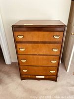 Front view showing full chest with four deep drawers and gilded pulls