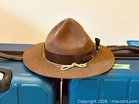 Full view of brown felt Scouts Canada hat resting on suitcase