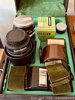 Open fitted case showing lenses, teleconverter, extension tube box, flash, filter, cable and case interior