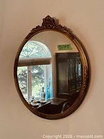 Frontal view of oval mirror reflecting room