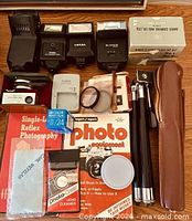 Group shot of entire lot showing flashes, charger, lens kit, tripods, books and accessories