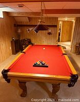 Overall view of pool table with red felt and accessories on top