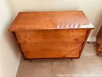 Front view of wooden three-drawer chest