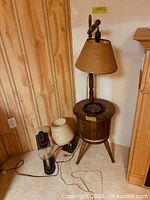 Full view of wood floor lamp with shade and two table lamps at base
