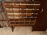 Front view of wooden card catalog cabinet showing 20 drawers and open cubbies below