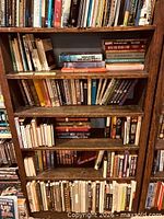 Full front view of wooden bookcase with books on shelves