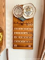 Full view of wooden calendar with plates displayed on top