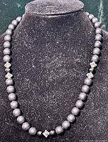 Necklace displayed on bust to show bead arrangement and length