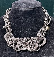 Full view of braided gunmetal statement necklace on display bust