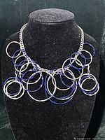 Front view of necklace on display bust showing ring design and clasp chain