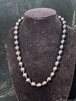 Full view of iridescent glass bead necklace on display bust