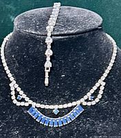 Full view of rhinestone choker necklace and matching bracelet on display bust