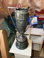 Full view of tall metal trophy on base