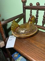 Side view of amber glass hen on nest covered dish