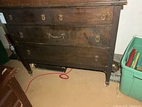 Front view of wooden dresser with four drawers and brass pulls